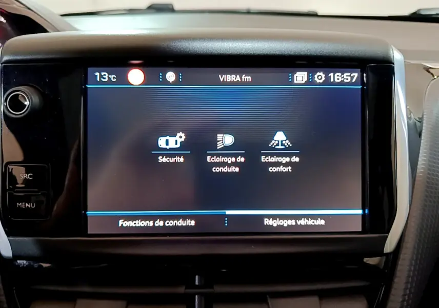 Écran tactile central du tableau de bord du Peugeot 2008 2019 affichant les réglages de sécurité et d’éclairage.