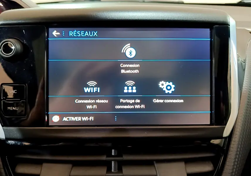 Écran tactile central affichant les options réseau Bluetooth et Wi-Fi dans l'habitacle d'un Peugeot 2008 gris foncé.
