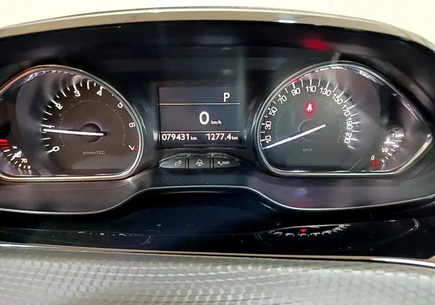 Tableau de bord du Peugeot 2008 gris foncé, affichage digital au centre avec compteur vitesse et compte-tours analogiques.