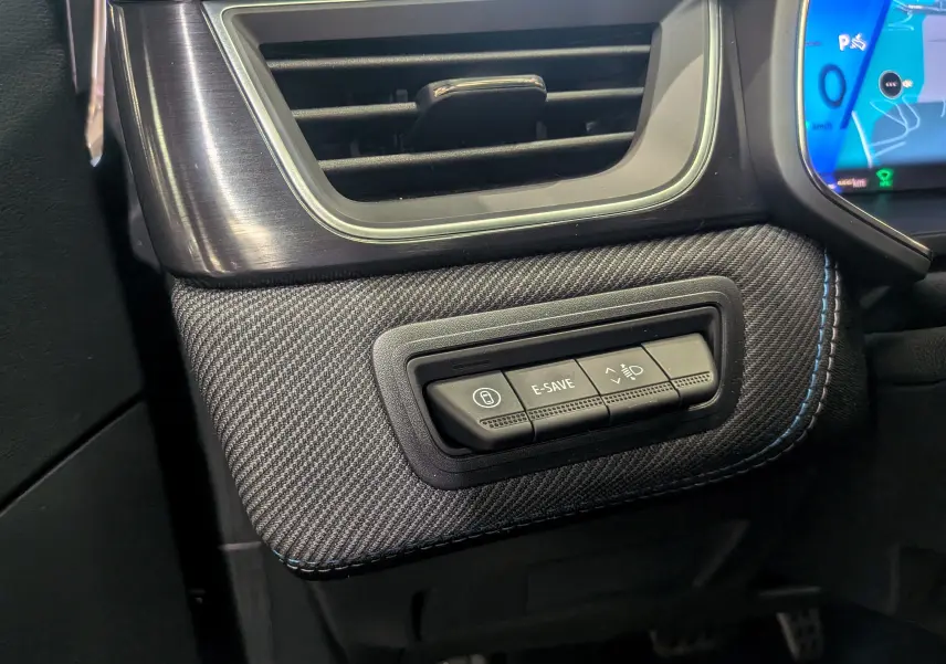 Détail intérieur côté gauche du tableau de bord gris cassiopé avec commandes E-SAVE et réglage des phares du Renault Symbioz 2026.