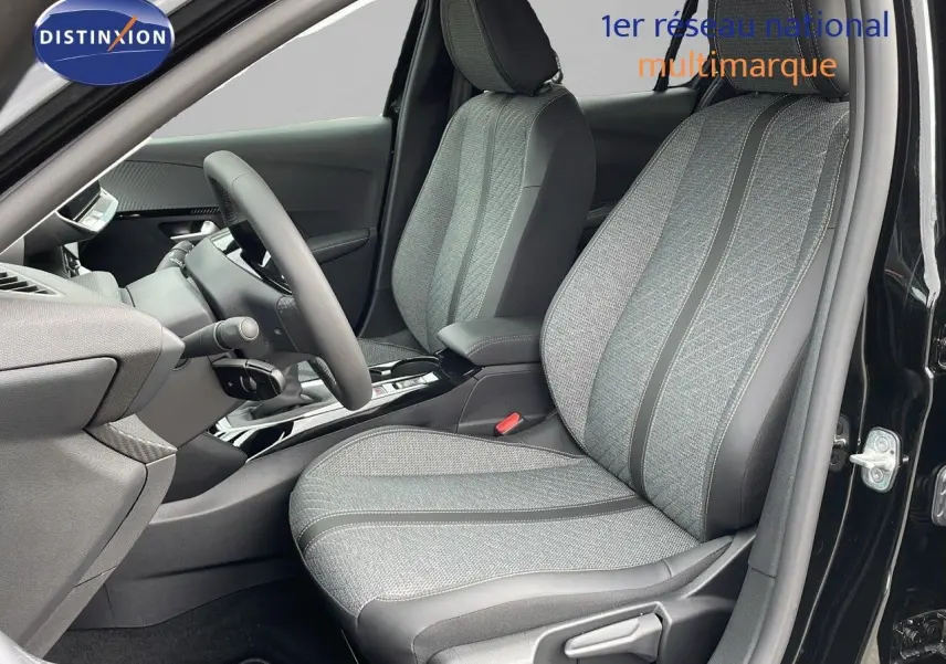 Vue intérieure côté conducteur de la Peugeot 208 2024 noire, sièges tissu gris avec surpiqûres et volant compact.