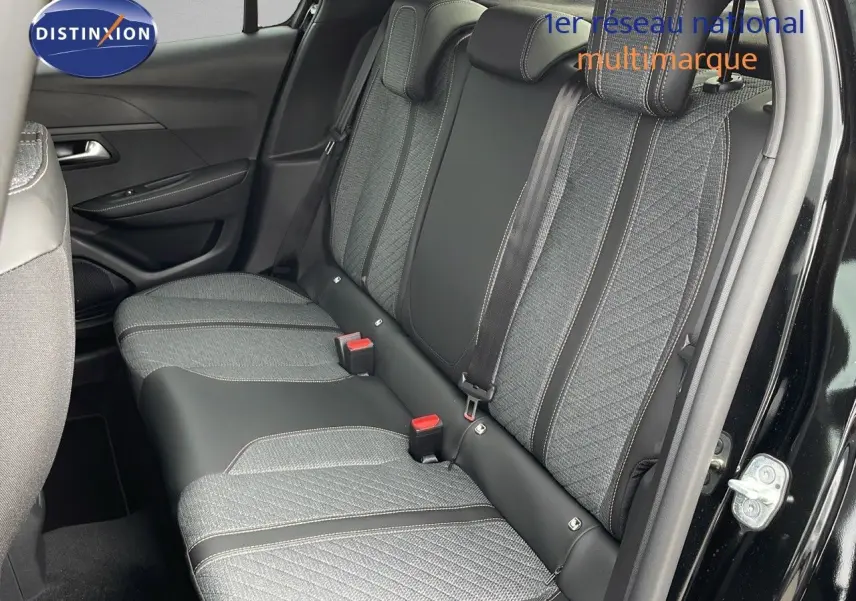 Vue latérale droite de l'arrière d'une Peugeot 208 noire avec sièges arrière en tissu gris et cuir noir.