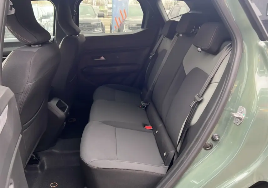 Vue côté gauche de l'habitacle arrière du Dacia Duster 2025 kaki lichen avec banquette noire et ceintures visibles