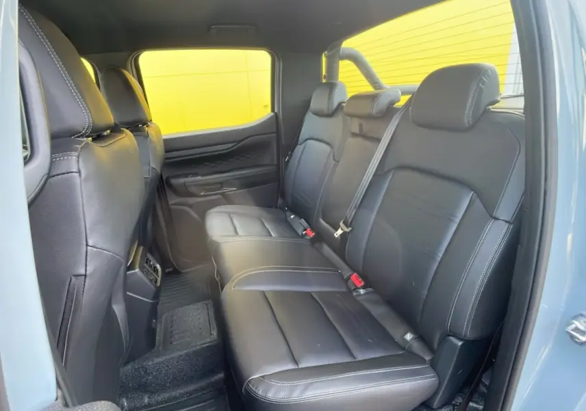 Vue intérieure arrière côté droit du Ford Ranger 2025 avec sièges en cuir noir et arceau noir visible.