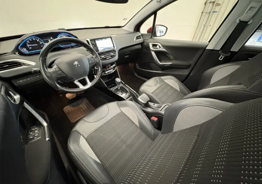 Intérieur noir du Peugeot 2008 2019, vue côté conducteur, volant cuir et écran tactile central visible.
