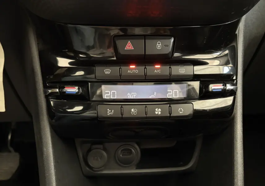 Panneau de commande de la climatisation digitale noir brillant dans l’habitacle du Peugeot 2008 rouge, version Allure.