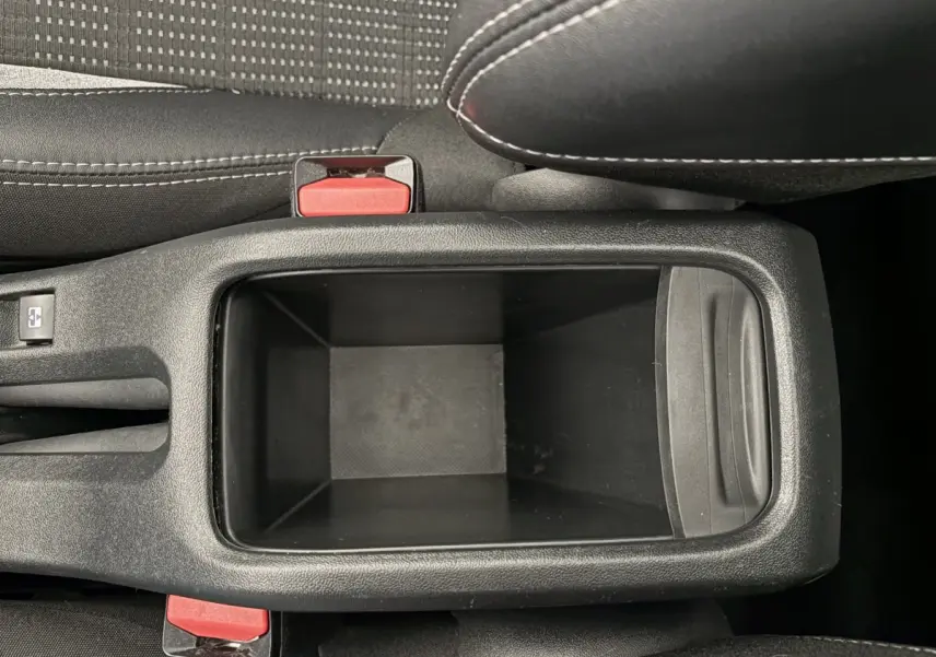 Vue plongeante sur le rangement central noir entre les sièges avant du Peugeot 2008 rouge Puretech 2019