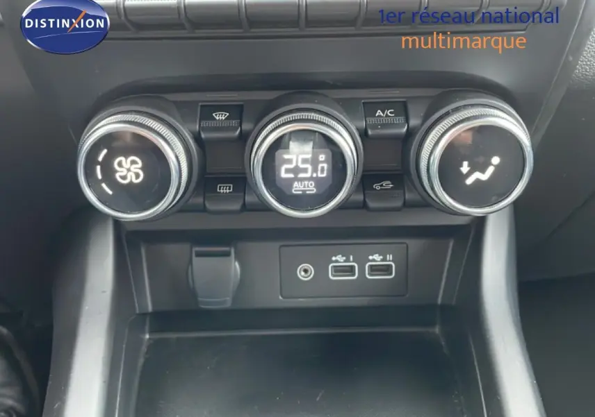 Détail de la console centrale avec commandes de climatisation et ports USB du Renault Arkana bleu Zanzibar 2025.