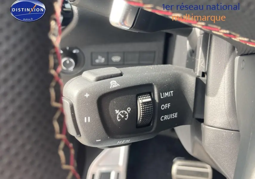 Gros plan sur la commande de régulateur de vitesse du DS7 1.5 BlueHDi 130 Performance Line, intérieur noir avec surpiqûres rouges.