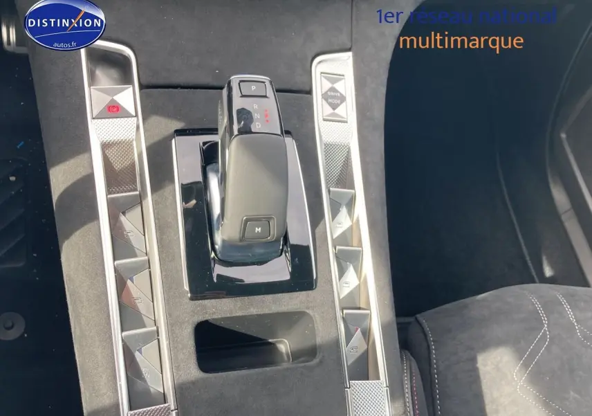 Vue rapprochée de la console centrale du DS7 1.5 BlueHDi 130 en Crystal Pearl, avec levier de vitesse automatique et finitions alu.