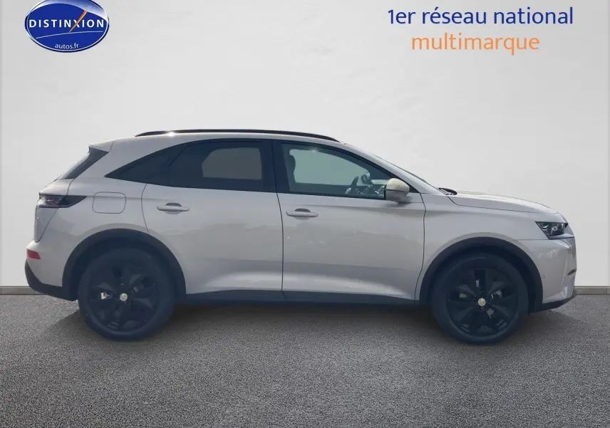 Vue de profil côté gauche du DS7 1.5 BlueHDi 130 Crystal Pearl avec jantes noires et vitres surteintées.