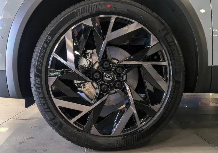 Gros plan sur la roue avant droite du Renault Symbioz gris Rafale, jante noire et argentée au design géométrique.