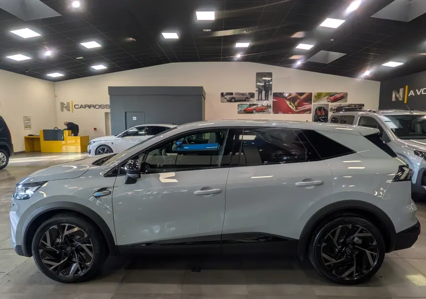 Vue de profil côté gauche du Renault SYMBIOZ gris Rafale en hybride, avec jantes noires et toit noir contrastant.