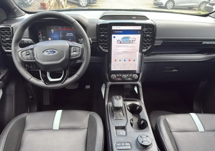 Vue intérieure frontale du Ford Ranger 2.3 PHEV avec tableau de bord noir et écran tactile vertical central.