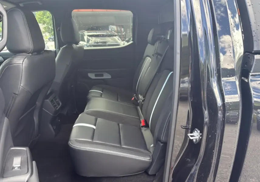 Vue intérieure côté droit sur la banquette arrière en cuir noir du Ford Ranger 2025 noir agate avec porte ouverte.