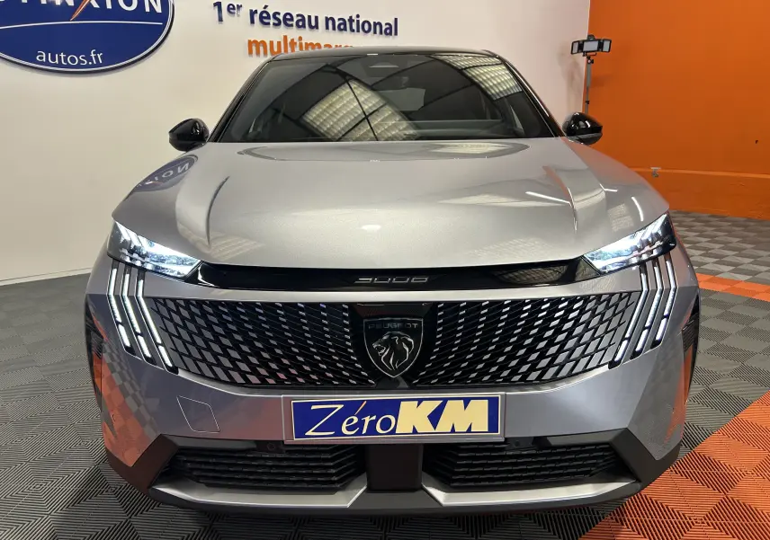 Vue frontale d’un Peugeot 3008 III Hybrid gris Artense avec calandre noire et feux LED distinctifs allumés.