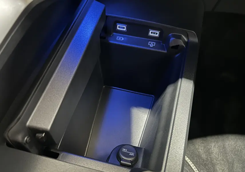 Gros plan intérieur sur la console centrale du Peugeot 3008 Hybrid gris, montrant deux ports USB et une prise 12V.