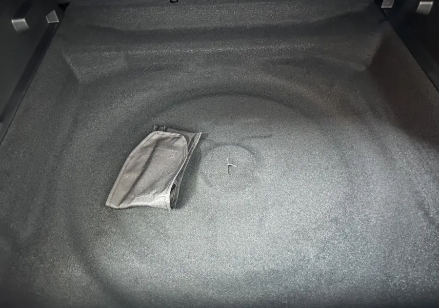 Coffre vide vu de dessus du Peugeot 3008 III Hybrid gris Artense avec tapis de sol plié au centre.