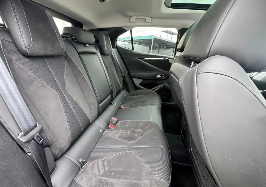 Vue intérieure arrière du DS4 2022 avec sièges en cuir et Alcantara noir, toit ouvrant panoramique visible.