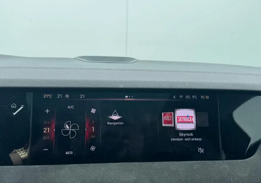 Tableau de bord numérique de DS4 Performance Line, affichant la climatisation et la radio Skyrock à l'avant.