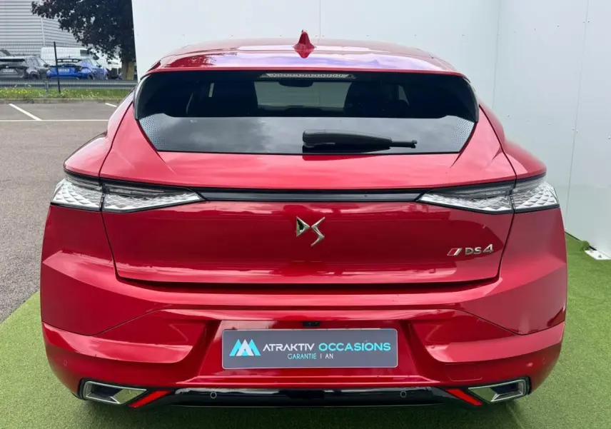 Vue arrière d'une DS4 rouge foncé avec feux arrière 3D et double sortie d'échappement chromée.