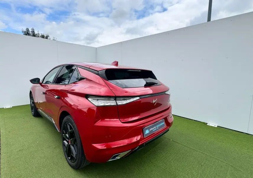 Vue 3/4 arrière droite d'une DS4 rouge foncé avec feux arrière LED et double sortie d'échappement chromée.