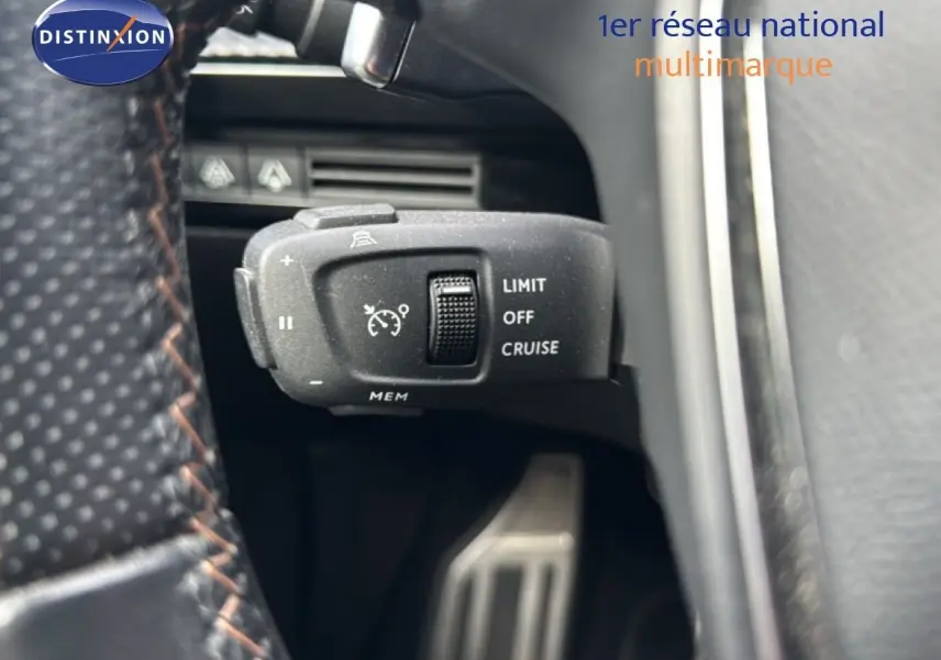 Gros plan sur la commande de régulateur de vitesse au volant d’une Peugeot 508 gris platinium, intérieur cuir noir.