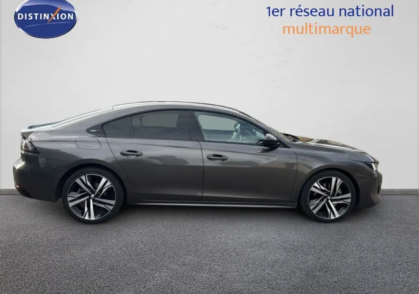 Profil droit d'une Peugeot 508 gris platinium de 2020, finition GT Line avec jantes alliage bicolores et attelage visible.