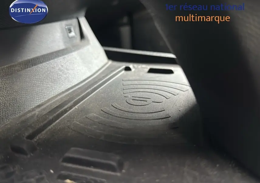 Gros plan sur le tapis de recharge sans fil dans l'habitacle d'une Peugeot 508 gris platinium.