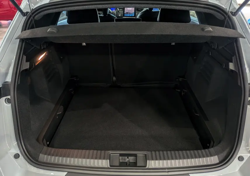 Coffre ouvert vu de l'arrière d'une Renault Symbioz gris Rafale, intérieur noir et tablette cache-bagages visible.