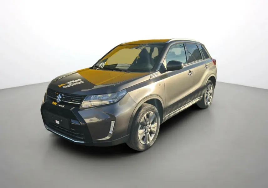 Suzuki Vitara Hybrid 110 Privilege AllGrip 2025 en gris titan, vue 3/4 avant avec jantes alu 17 pouces et feux LED.