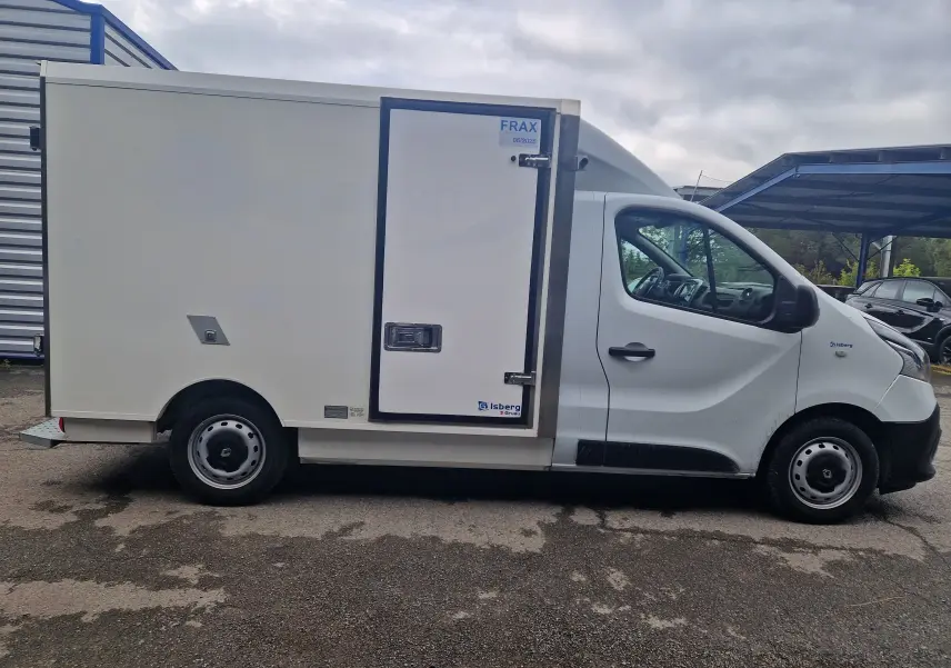 Vue latérale droite d'un utilitaire Renault Trafic blanc avec caisse frigorifique Iceberg et porte latérale isolée.