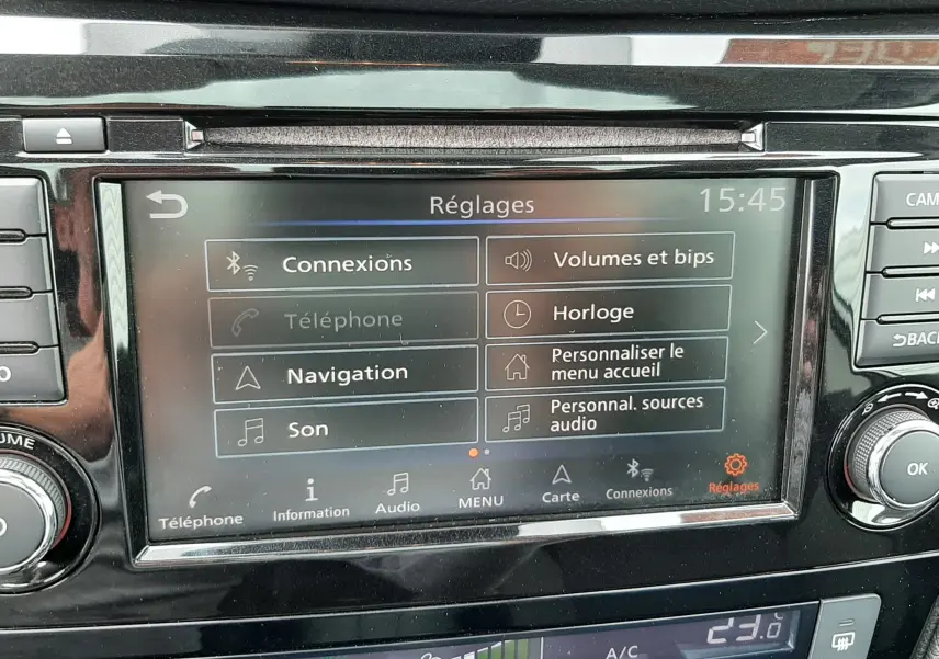 Écran tactile central du Nissan Qashqai blanc 2020 affichant le menu réglages avec commandes climatisation en dessous.