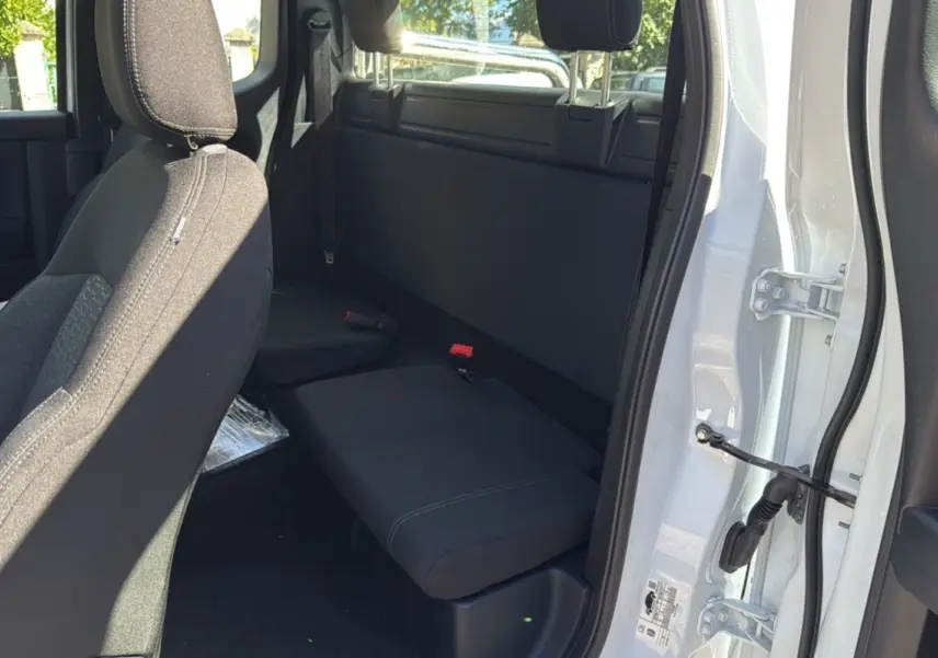 Vue intérieure côté droit du Ford Ranger blanc glacier 2025, montrant la banquette arrière compacte et la portière ouverte.