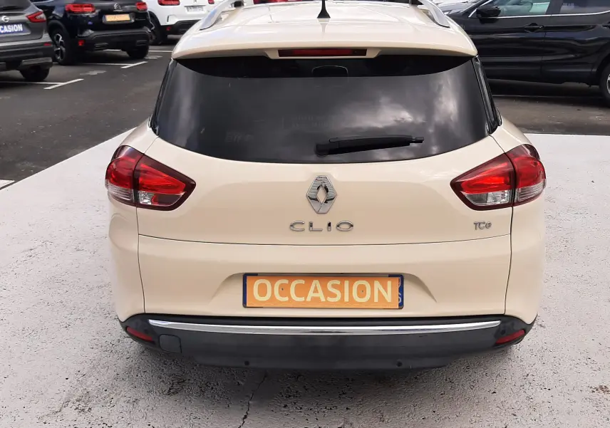 Vue arrière d'une Renault Clio IV Estate beige de 2016 avec vitres teintées et plaque "Occasion" visible.