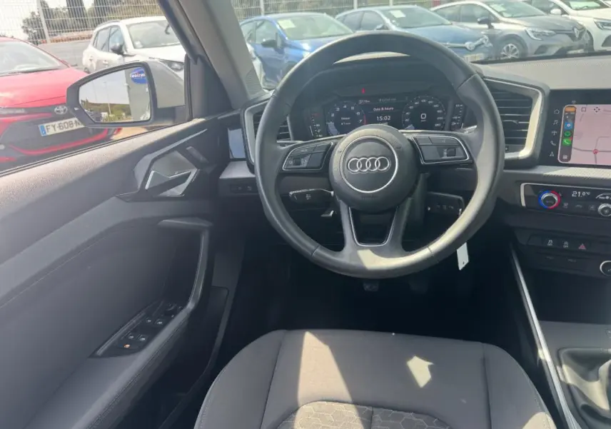 Vue intérieure centrée sur le volant cuir et le cockpit numérique de l'Audi A1 Sportback 2025 en gris.
