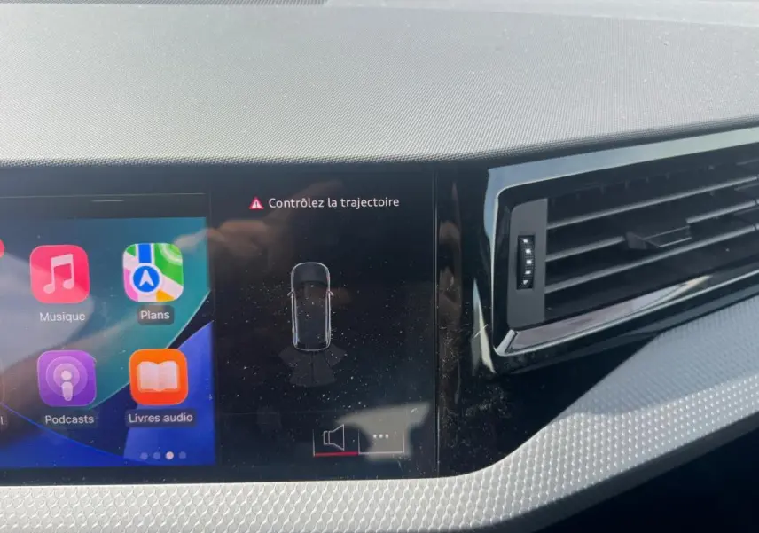 Vue rapprochée du tableau de bord gris de l'Audi A1 Sportback 2025 avec écran tactile et ventilation latérale.
