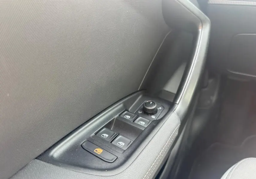 Gros plan sur la commande des vitres électriques côté conducteur d’une Audi A1 Sportback gris 2025.