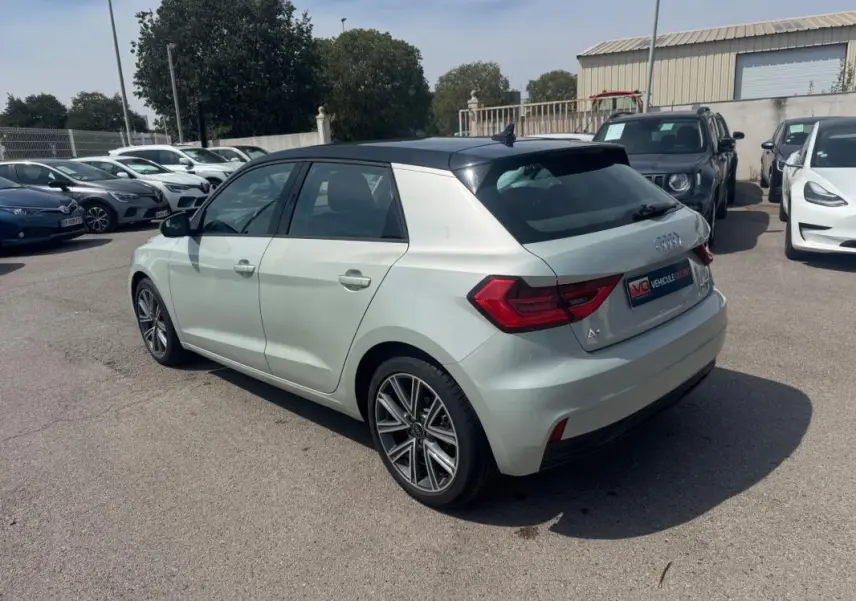 Audi A1 Sportback gris clair vue 3/4 arrière droit avec toit noir et jantes alliage distinctives.