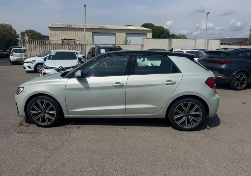 Audi A1 Sportback gris vue de profil côté gauche, avec toit noir et jantes alliage distinctives.