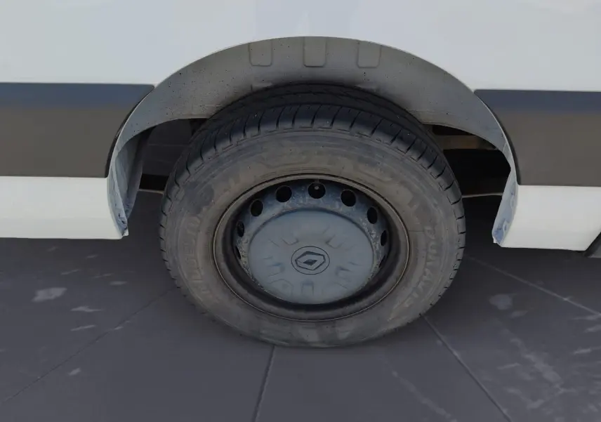 Gros plan sur la roue arrière droite d’un Renault Master blanc, avec jante acier et enjoliveur Renault visible.