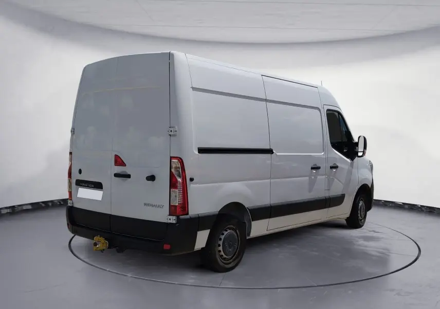 Vue 3/4 arrière droit d’un Renault Master blanc utilitaire avec hayon et attelage dans un studio gris.