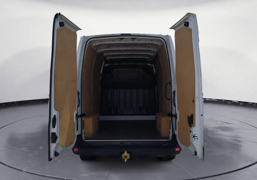 Vue arrière du Renault Master blanc L2H2 2022 avec portes ouvertes montrant l’espace de chargement vide et habillage bois intérieur.