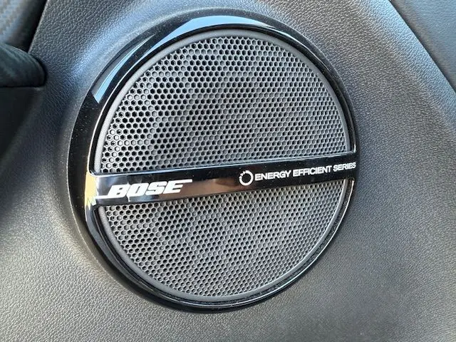 Gros plan sur l'enceinte Bose intégrée dans l'habitacle du Renault Mégane III Coupé Blanc Nacré.