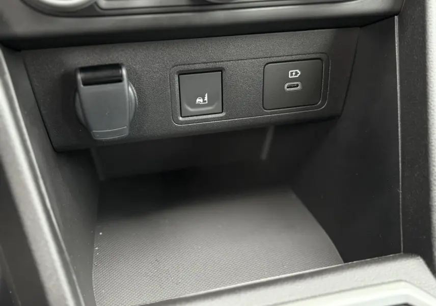 Gros plan sur la console centrale de la Dacia Sandero Stepway 2025, montrant les prises USB et le bouton d’aide au maintien.