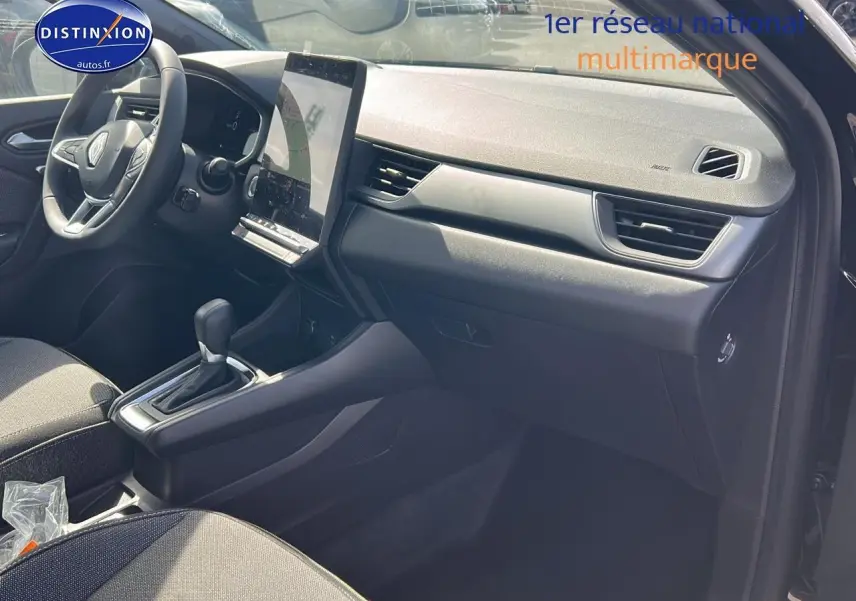 Vue intérieure côté passager du tableau de bord et console centrale du Renault Captur 1.6 e-tech hybride noir étoile 2025.