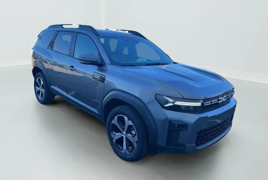 Vue 3/4 avant droite du Dacia Bigster 155 Journey gris schiste avec jantes alliage 18'' et barres de toit longitudinales.