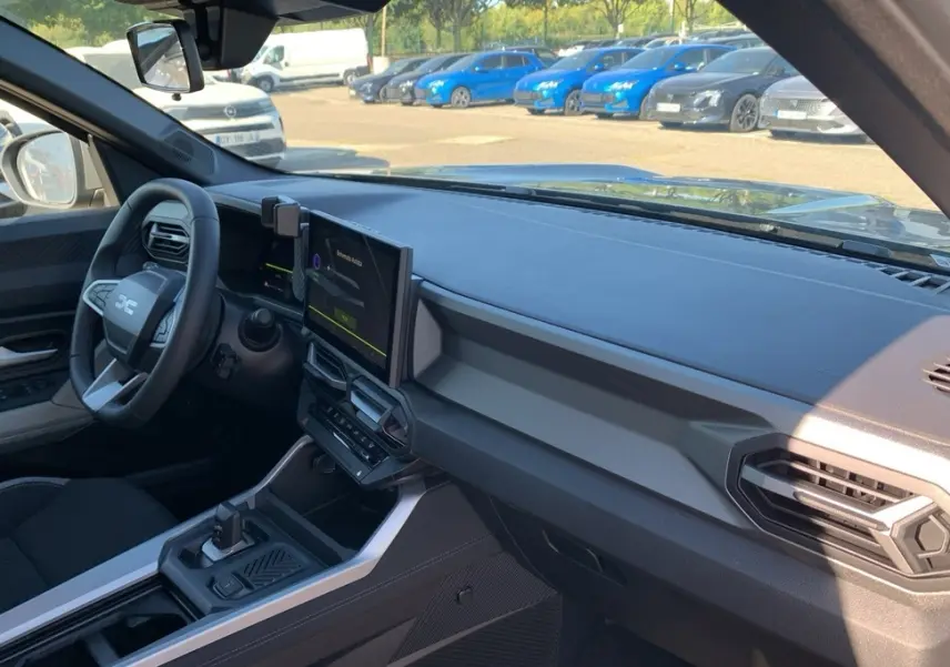 Vue intérieure côté conducteur du tableau de bord et volant du Dacia Bigster 155 Journey avec écran tactile central.