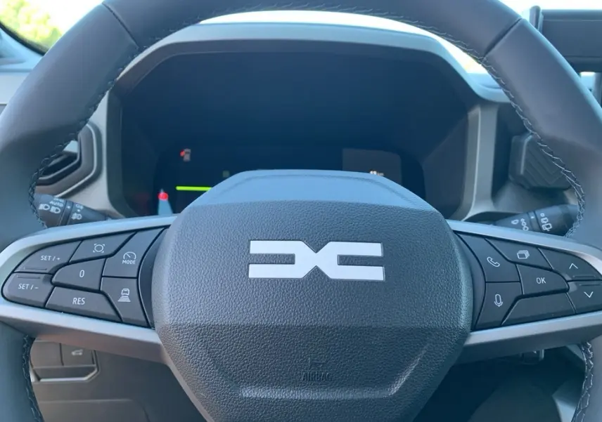 Gros plan sur le volant Soft Feel du Dacia Bigster 155 Journey avec commandes intégrées et logo central distinctif.