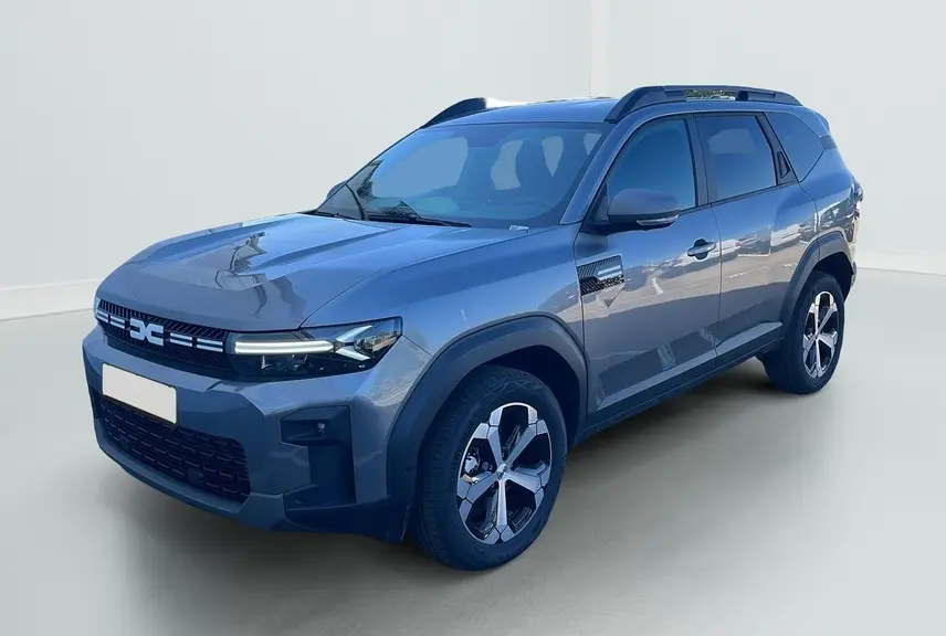 SUV Dacia Bigster 155 Journey gris schiste en 3/4 avant, avec jantes alliage 18'' et barres de toit longitudinales.